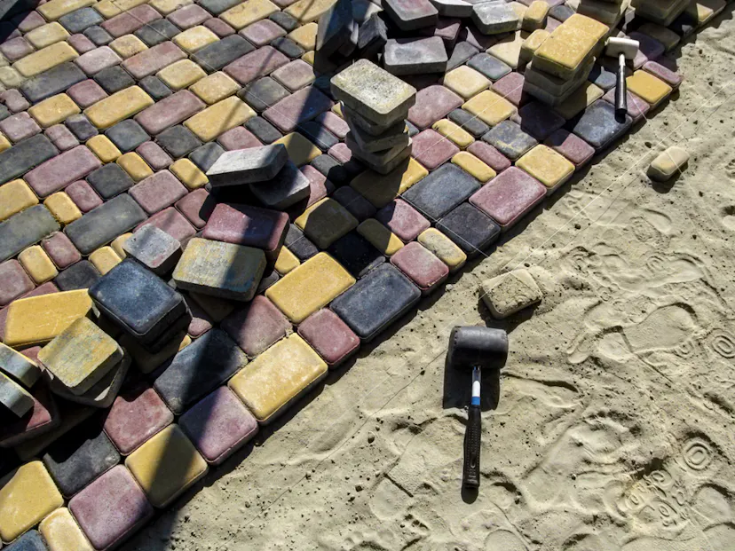 Brick laying area with hammer and brick in Paving and Driveway Essex UK.