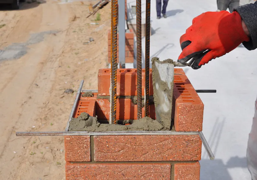 Bricklaying in Essex, UK - person constructing a wall with a brick.