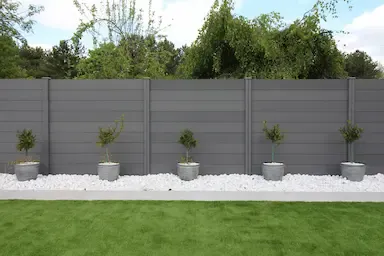 Pot of Plants In a garden In front of Composite Fence of concrete in Essex UK