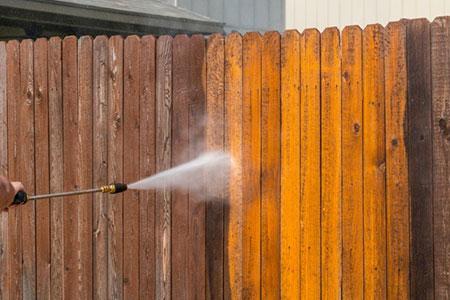 Cleaning wooden fence with pressure washer in Essex UK