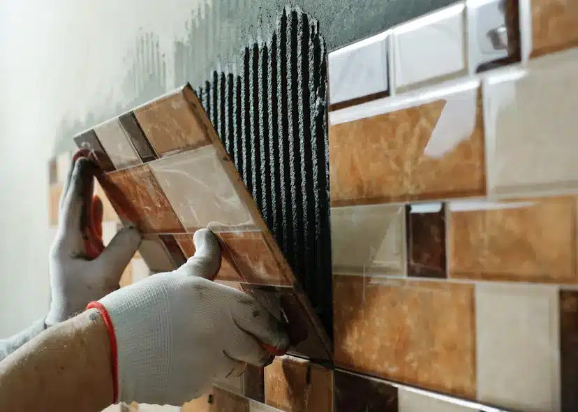 A tiller laying ceramic tiles on walls in Essex UK