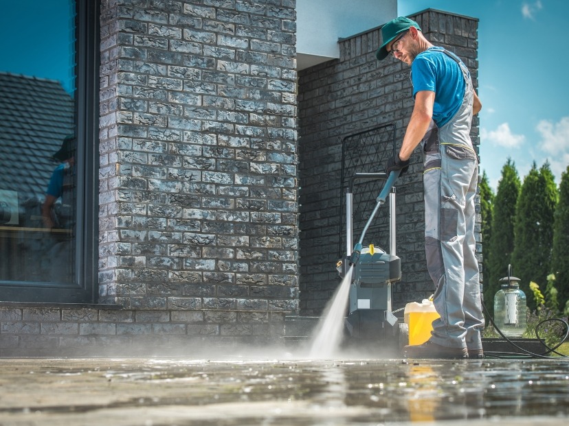 Home and garden master cleaning Driveway with pressure washer somewhere in Essex England UK in front of bricks wall